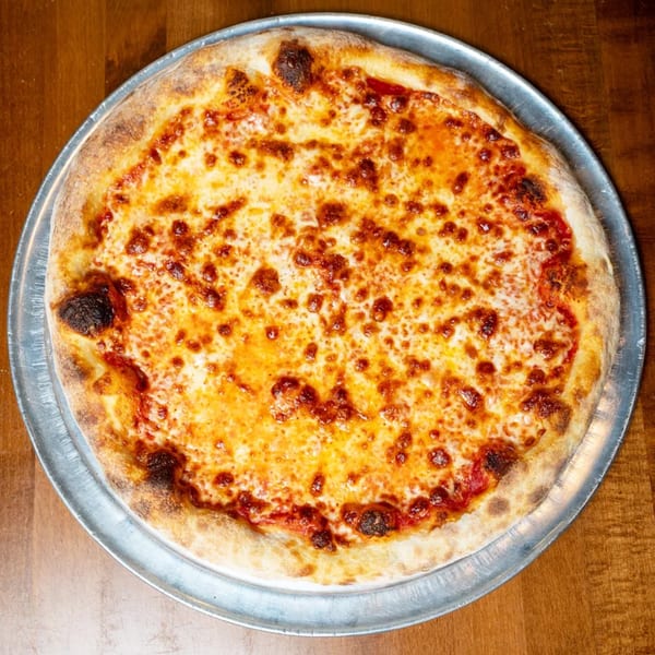 A whole cheese pizza with a golden crust on a metal tray, viewed from above.